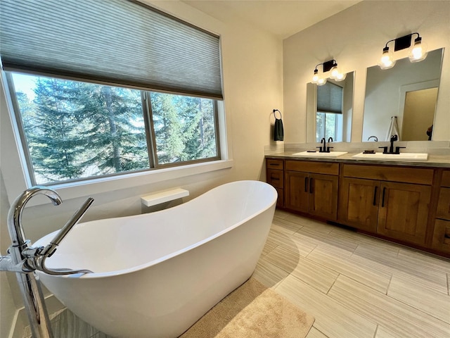 full bathroom featuring double vanity, a soaking tub, and a sink