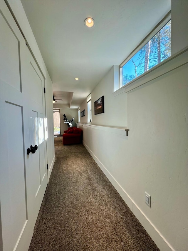 hall featuring carpet floors, a wealth of natural light, baseboards, and recessed lighting