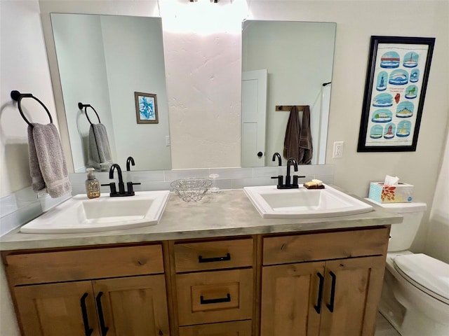 full bathroom featuring a sink, toilet, and double vanity