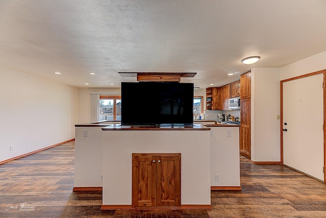 kitchen with decorative backsplash, dark countertops, stainless steel microwave, dark wood-type flooring, and fridge