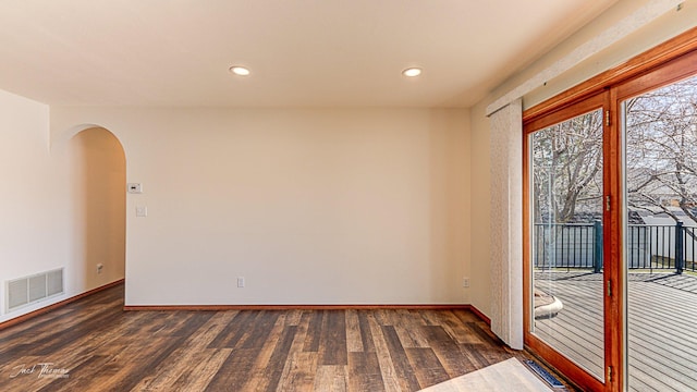 unfurnished room with visible vents, arched walkways, wood finished floors, and recessed lighting