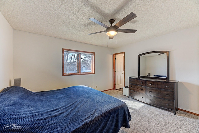 carpeted bedroom featuring ceiling fan, a textured ceiling, and baseboards