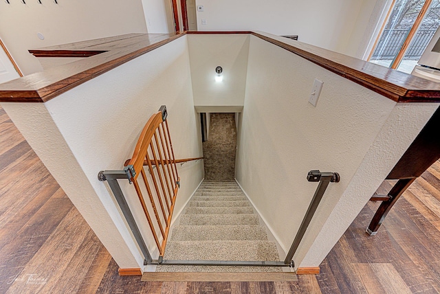 stairs with wood finished floors and baseboards