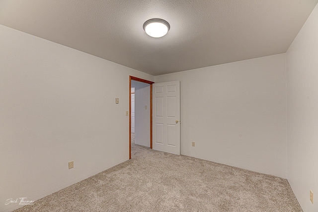 carpeted empty room with a textured ceiling