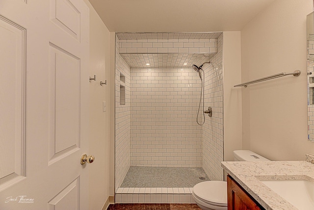 bathroom featuring a stall shower, vanity, and toilet