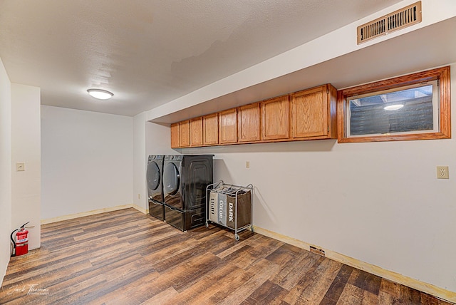 interior space featuring cabinet space, visible vents, washer and clothes dryer, and dark wood-type flooring