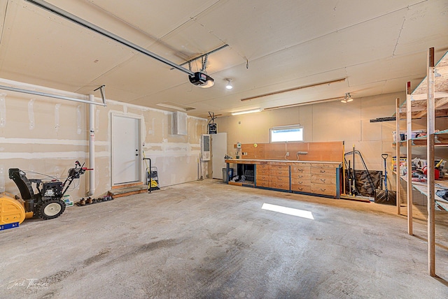 garage with a workshop area and a garage door opener