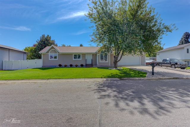 ranch-style home with an attached garage, fence, a front lawn, and concrete driveway