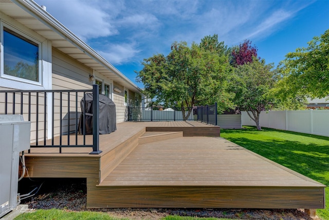 wooden terrace with a yard and fence