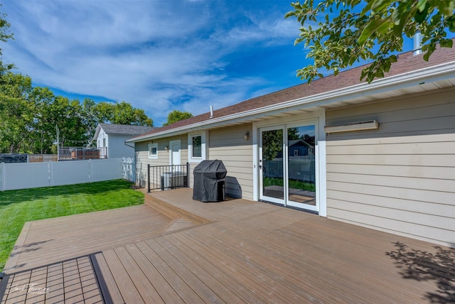 deck with a lawn and fence