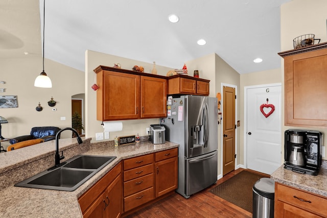 kitchen featuring arched walkways, stainless steel fridge with ice dispenser, dark wood-style floors, vaulted ceiling, and a sink