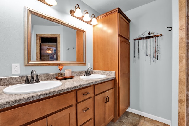 full bathroom with double vanity, baseboards, and a sink