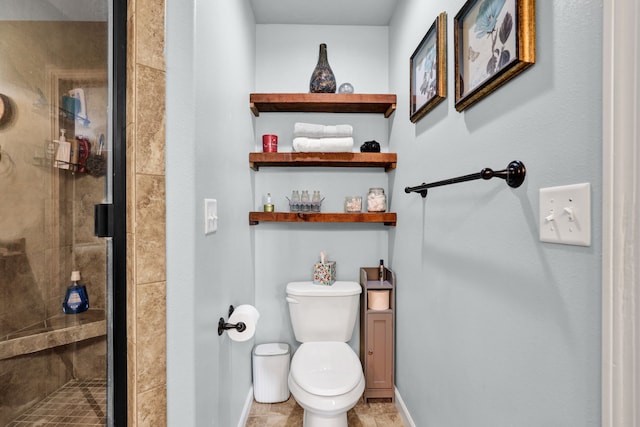 full bathroom featuring toilet, a stall shower, and baseboards