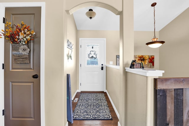 doorway featuring dark wood-style floors, baseboards, and arched walkways