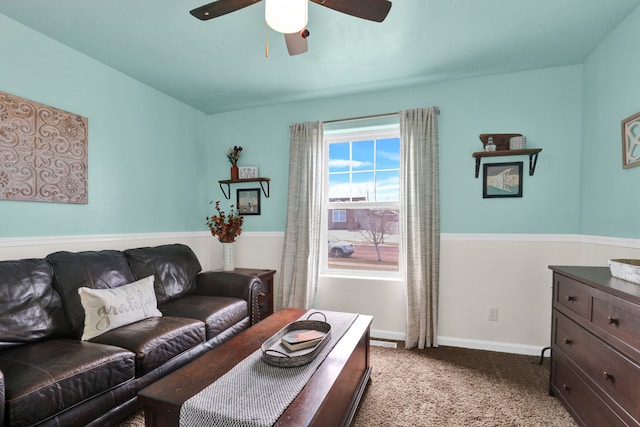 living area with light carpet, baseboards, and a ceiling fan