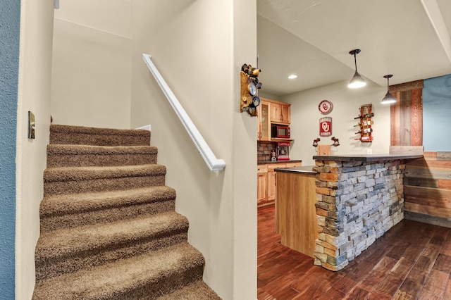 bar featuring a dry bar, dark wood finished floors, decorative light fixtures, stairs, and recessed lighting