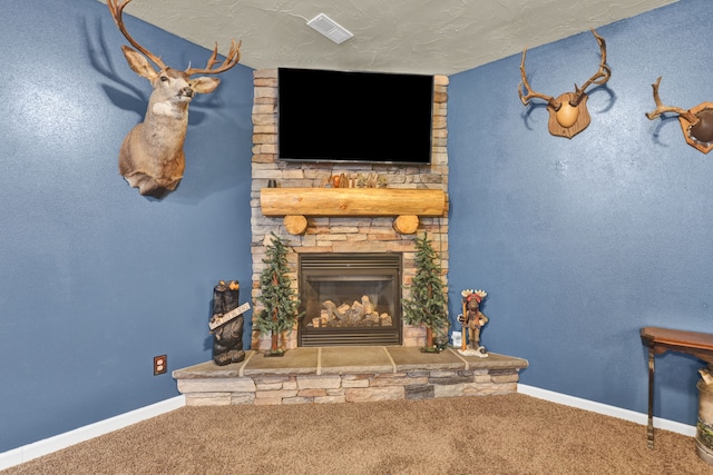 interior space featuring a stone fireplace, baseboards, and a textured ceiling