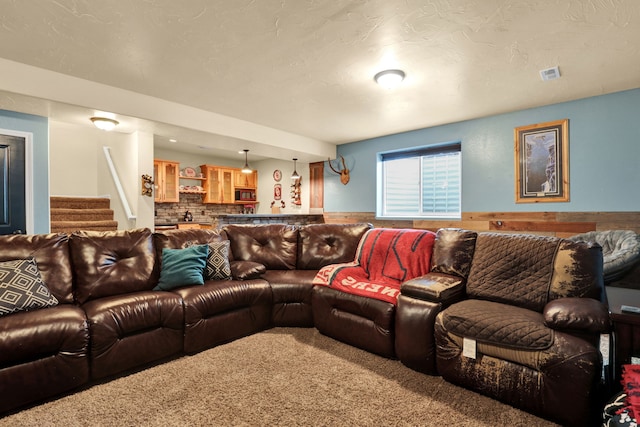 living room with a wainscoted wall, carpet, stairs, and visible vents