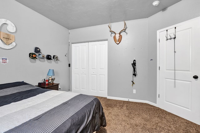 carpeted bedroom featuring a closet and baseboards