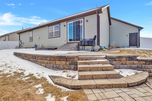 back of property featuring entry steps and fence