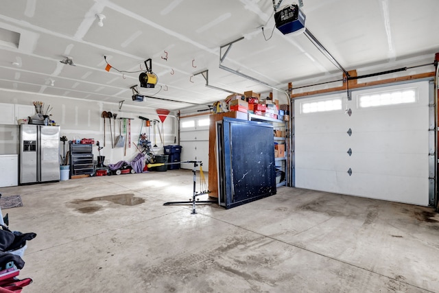 garage featuring stainless steel fridge and a garage door opener