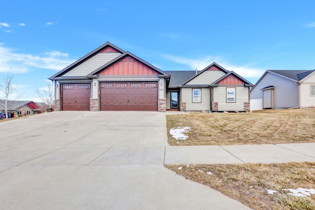 craftsman house with a garage, driveway, a front lawn, and board and batten siding