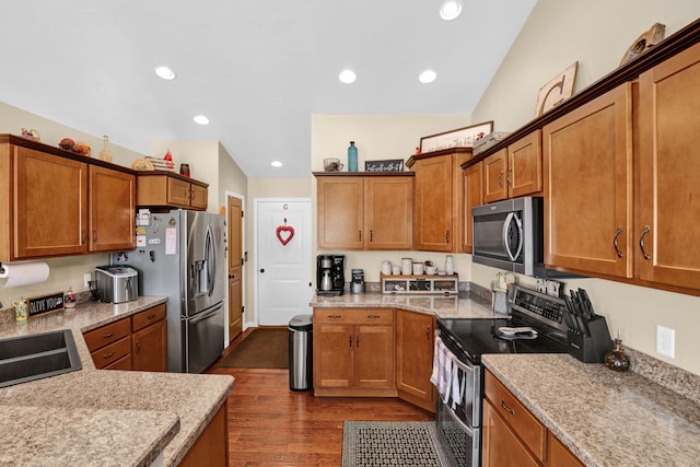 kitchen featuring appliances with stainless steel finishes, recessed lighting, dark wood finished floors, and brown cabinets