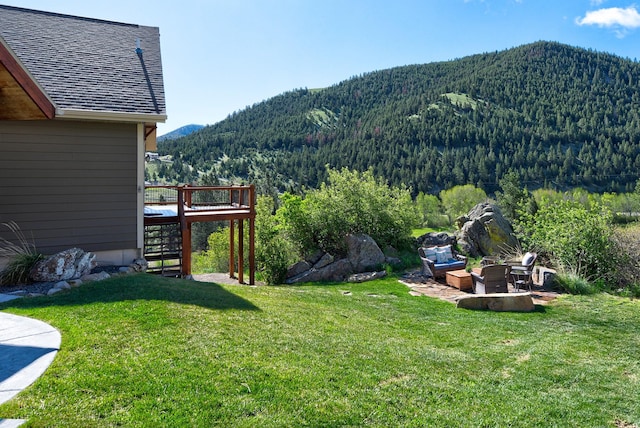 view of yard with stairs, a forest view, and a deck with mountain view