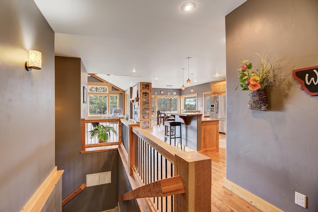 staircase with baseboards, wood finished floors, visible vents, and recessed lighting