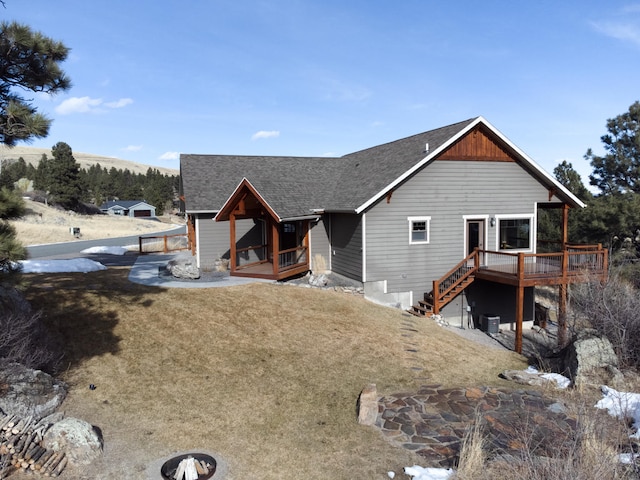 chalet / cabin featuring stairway, roof with shingles, and a wooden deck