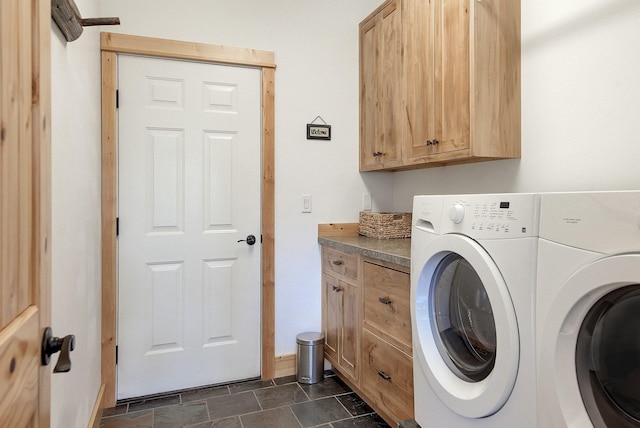 clothes washing area featuring washing machine and dryer and cabinet space