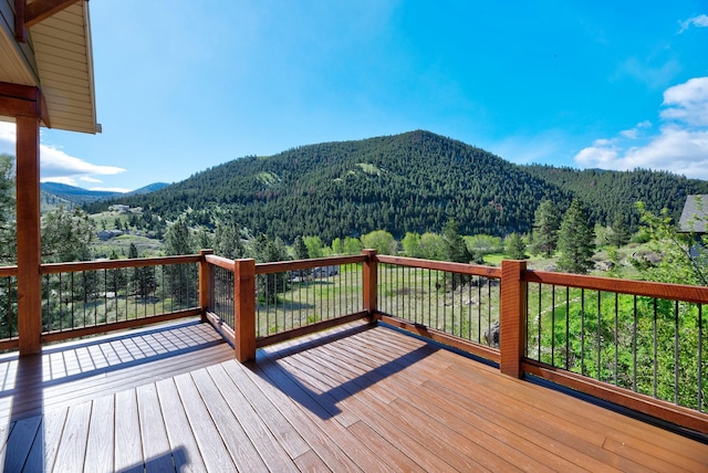 wooden deck featuring a mountain view and a wooded view