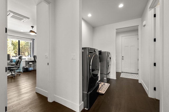 clothes washing area with laundry area, dark wood-type flooring, washer and clothes dryer, and baseboards