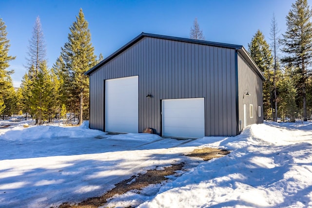 snow covered garage featuring a detached garage