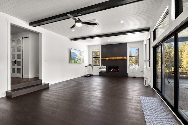 unfurnished living room with a large fireplace, beamed ceiling, dark wood-style floors, and baseboards