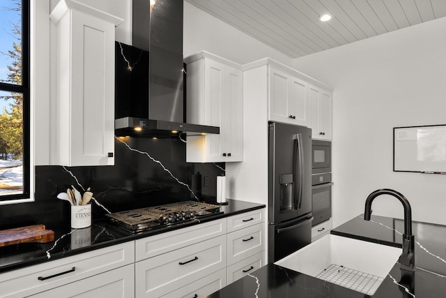 kitchen with white cabinets, wall chimney range hood, black appliances, tasteful backsplash, and dark countertops