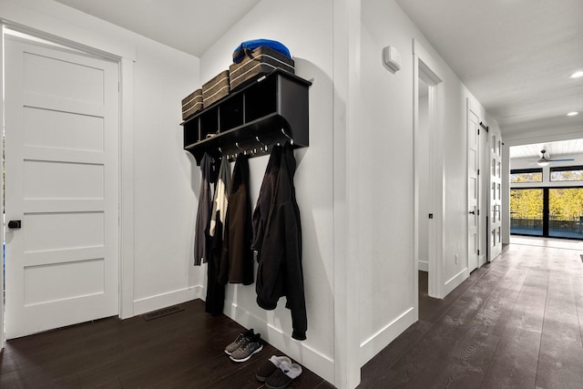 mudroom featuring dark wood-style floors, ceiling fan, visible vents, and baseboards