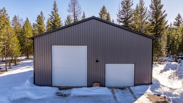 snow covered garage featuring a detached garage