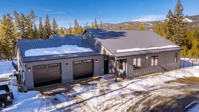 view of front of home with a garage, metal roof, and a mountain view