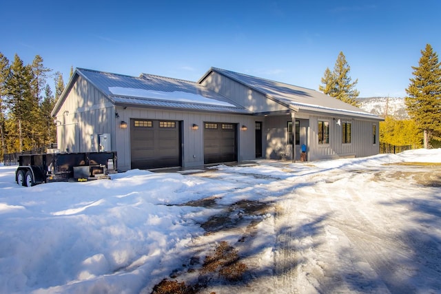 view of front of home with an attached garage, metal roof, and board and batten siding