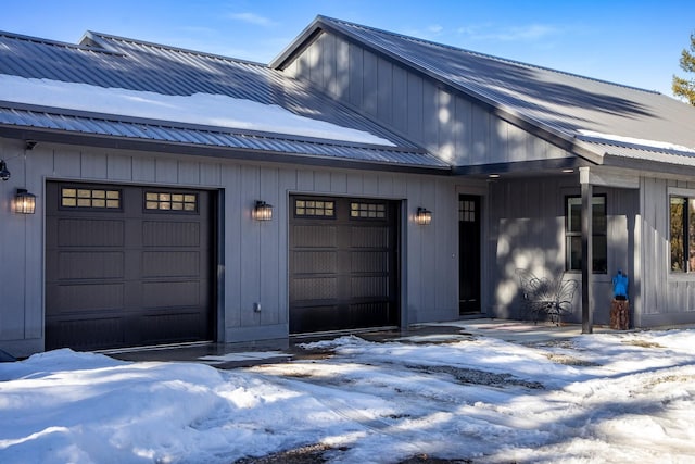 exterior space featuring board and batten siding, metal roof, and an attached garage