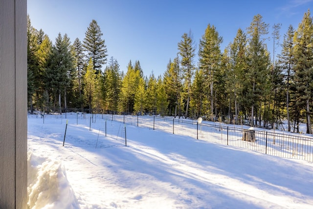 yard layered in snow featuring fence