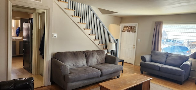 living area with light wood finished floors and stairs