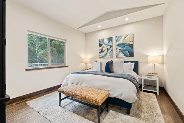 230 Forest Edge Trl, Kalispell, MT 59901 - bedroom featuring visible vents, multiple windows, dark wood-style floors, and vaulted ceiling