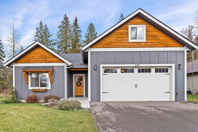230 Forest Edge Trl, Kalispell, MT 59901 - craftsman house with board and batten siding, an attached garage, a front lawn, and aphalt driveway