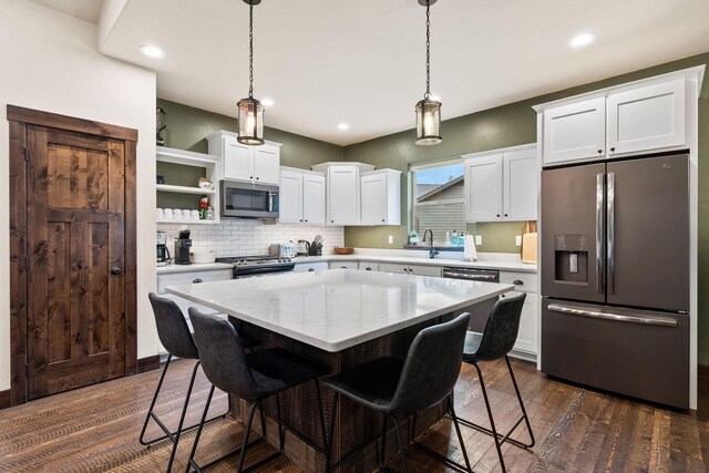 230 Forest Edge Trl, Kalispell, MT 59901 - kitchen featuring a kitchen breakfast bar, dark wood finished floors, stainless steel appliances, white cabinetry, and a kitchen island