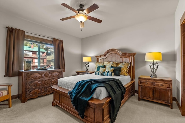 bedroom with light colored carpet, ceiling fan, and baseboards