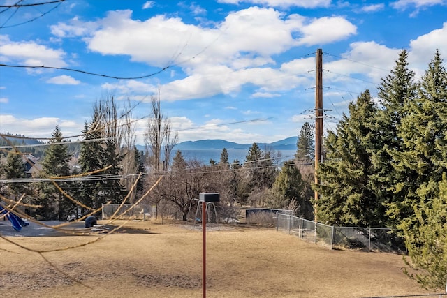 view of yard featuring fence and a mountain view