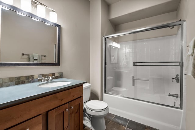 bathroom featuring combined bath / shower with glass door, vanity, toilet, and tile patterned floors