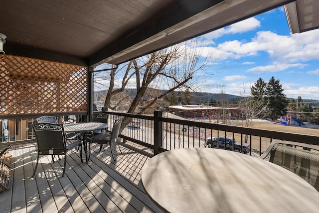 deck with outdoor dining space and a mountain view